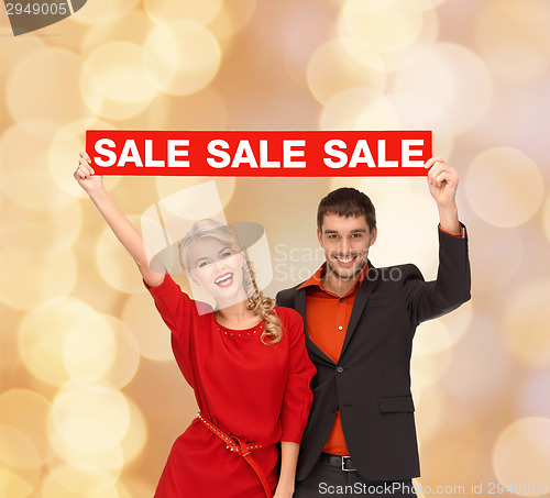 Image of smiling couple with red sale sign