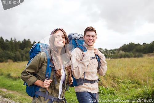 Image of smiling couple with backpacks hiking