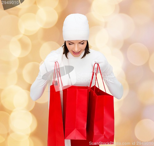 Image of smiling young woman with red shopping bags