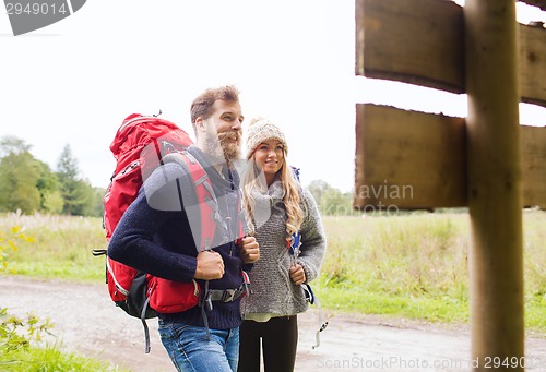 Image of smiling couple with backpacks hiking