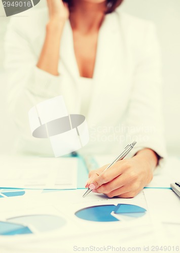 Image of woman with documents taking phone call