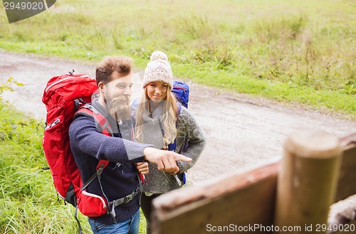 Image of smiling couple with backpacks hiking