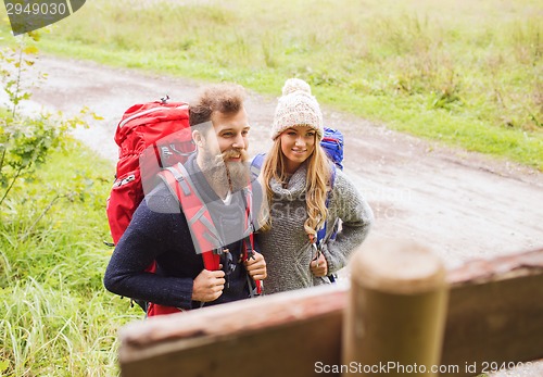 Image of smiling couple with backpacks hiking