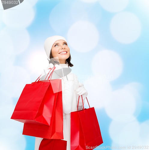 Image of smiling young woman with red shopping bags