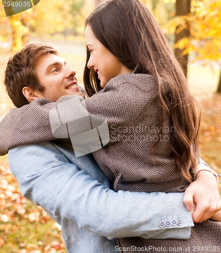 Image of smiling couple hugging in autumn park