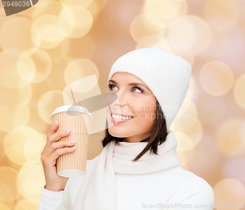 Image of smiling young woman in winter clothes with cup