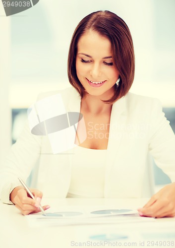 Image of businesswoman working with graphs in office