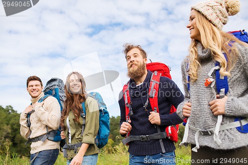 Image of group of smiling friends with backpacks hiking