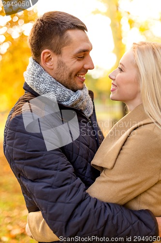 Image of smiling couple hugging in autumn park