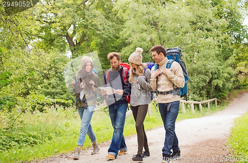 Image of group of smiling friends with backpacks hiking