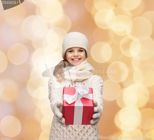 Image of dreaming girl in winter clothes with gift box