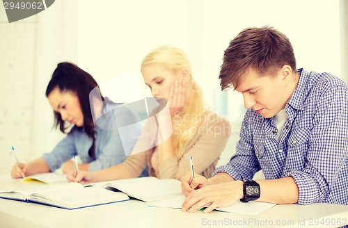 Image of tired students with notebooks at school