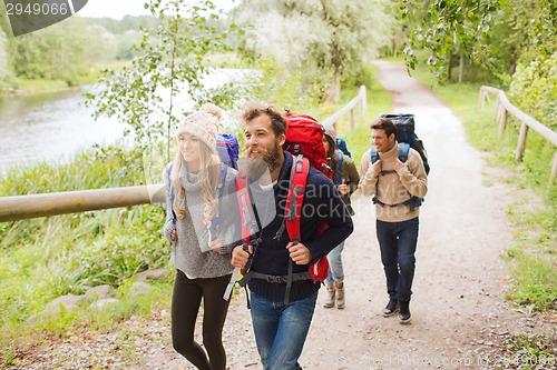 Image of group of smiling friends with backpacks hiking