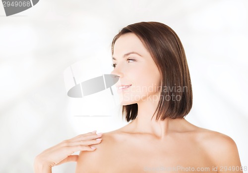 Image of beautiful woman touching her shoulders