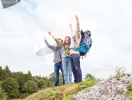 Image of group of smiling friends with backpacks hiking