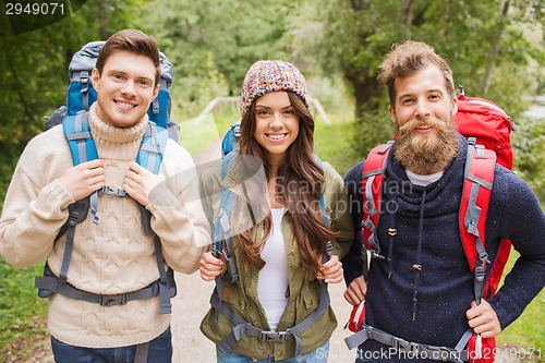 Image of group of smiling friends with backpacks hiking