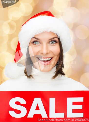 Image of smiling woman in santa helper hat with sale sign