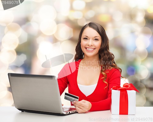 Image of smiling woman with credit card and laptop