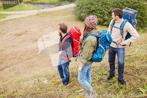 Image of group of smiling friends with backpacks hiking