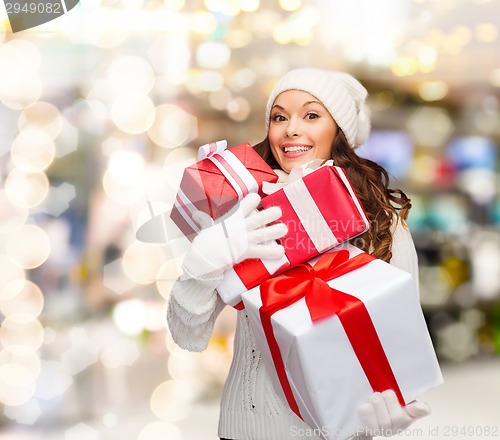 Image of smiling young woman in santa helper hat with gifts