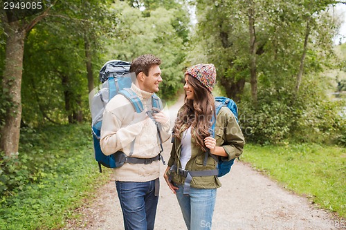 Image of smiling couple with backpacks hiking