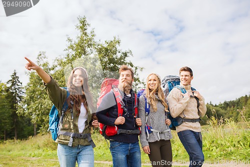 Image of group of smiling friends with backpacks hiking