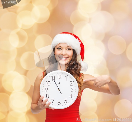 Image of smiling woman in santa helper hat with clock