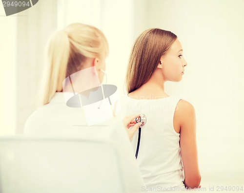 Image of doctor with stethoscope listening to child back