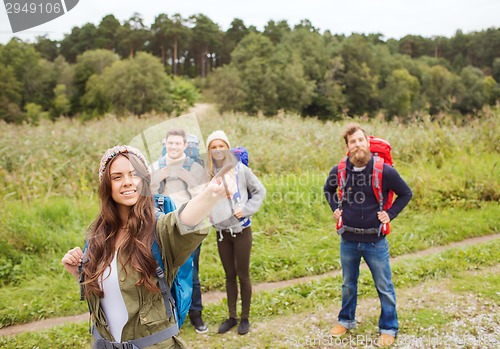 Image of group of smiling friends with backpacks hiking