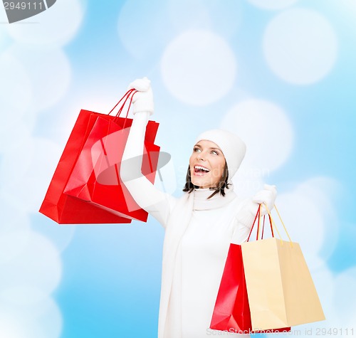 Image of smiling young woman with red shopping bags