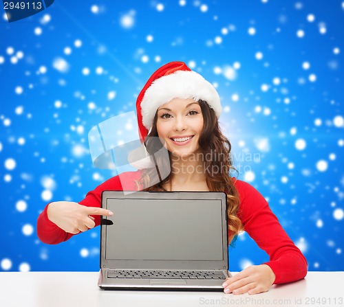 Image of smiling woman in santa helper hat with laptop