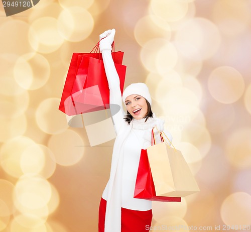 Image of smiling young woman with red shopping bags