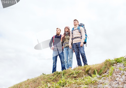 Image of group of smiling friends with backpacks hiking