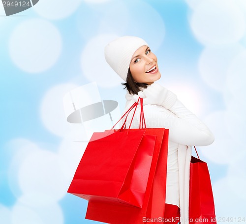 Image of smiling young woman with red shopping bags