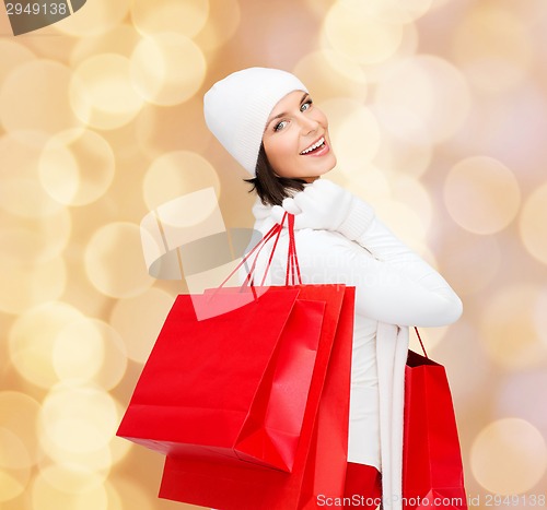 Image of smiling young woman with red shopping bags