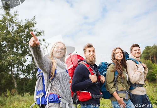 Image of group of smiling friends with backpacks hiking