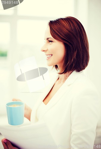 Image of woman with cup of coffee and papers