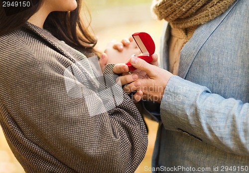 Image of close up of couple with gift box in park