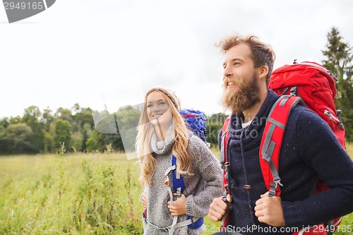 Image of smiling couple with backpacks hiking