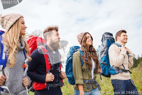 Image of group of smiling friends with backpacks hiking