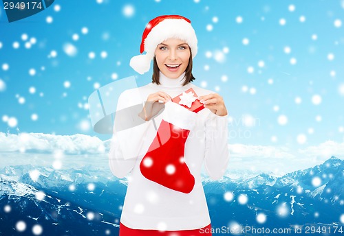 Image of woman in santa hat with gift box and stocking