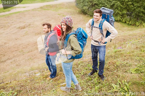 Image of group of smiling friends with backpacks hiking