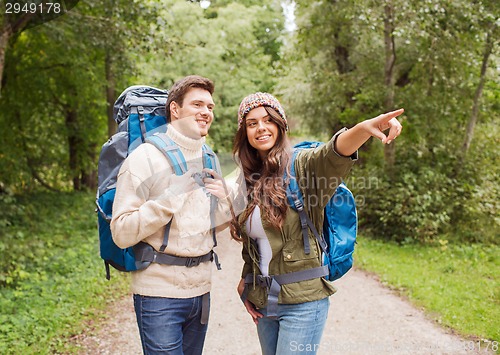 Image of smiling couple with backpacks hiking