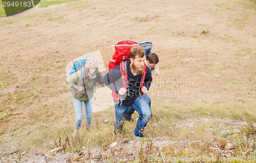 Image of group of smiling friends with backpacks hiking