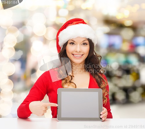 Image of smiling woman in santa hat with gift and tablet pc