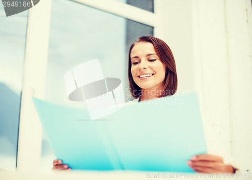 Image of businesswoman with folder in office