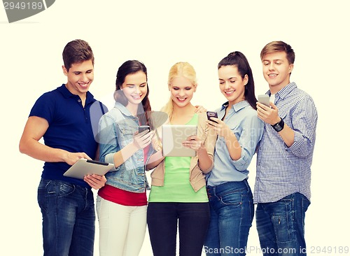 Image of smiling students using smartphones and tablet pc