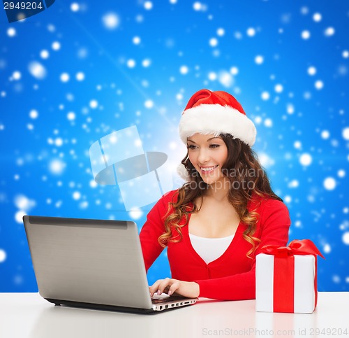 Image of smiling woman with gift box and laptop