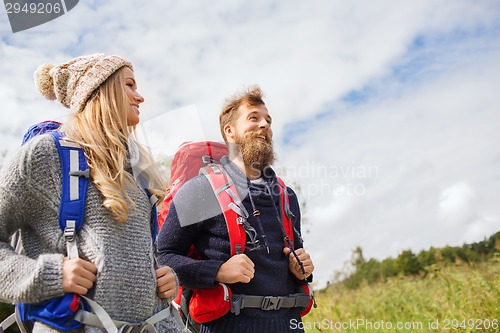 Image of smiling couple with backpacks hiking