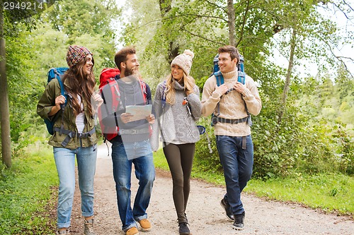 Image of group of smiling friends with backpacks hiking